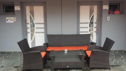 an outdoor table and chairs with an orange pillow on it at Apartments Akacijev Izvir in Miklavž na Dravskem Polju