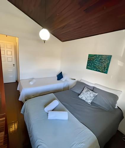 a small bedroom with two beds and a lamp at Casa da Lua Centro in Búzios