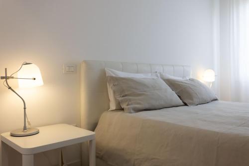 a bedroom with a white bed with a lamp on a table at Palermo ai Leoni in Palermo