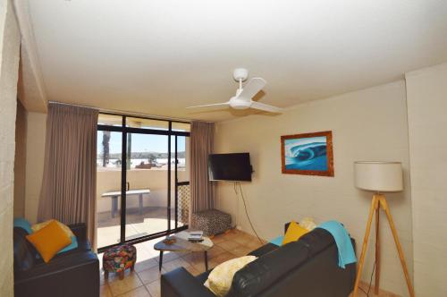 ein Wohnzimmer mit einer Couch und einem Deckenventilator in der Unterkunft Riverview Holiday Apartment 11 - Kalbarri, WA in Kalbarri