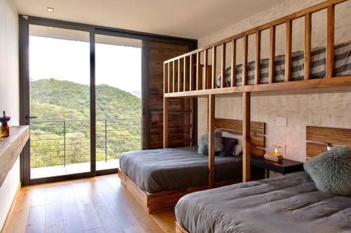 a bedroom with two bunk beds and a balcony at Espectacular casa con hermosa vista al lago - El Santuario Resort in Colorines