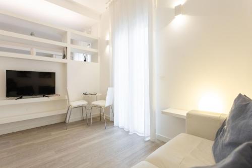 a living room with a couch and a tv at Palermo ai Leoni in Palermo