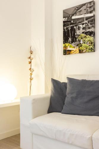 a white couch in a room with a picture on the wall at Palermo ai Leoni in Palermo