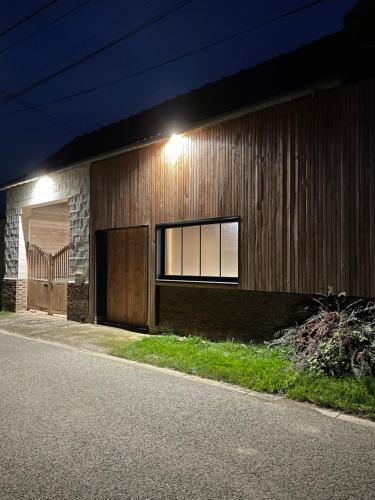 a building with a light on the side of it at Les Charmes de Villers in Huchenneville