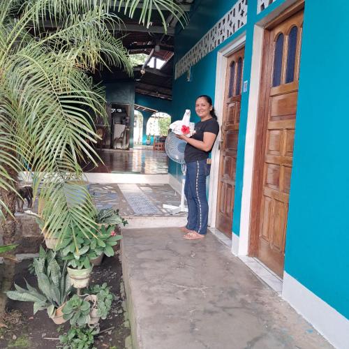 a woman standing in front of a building at Hospedaje y Restaurante la cocina de Mami in Moyogalpa