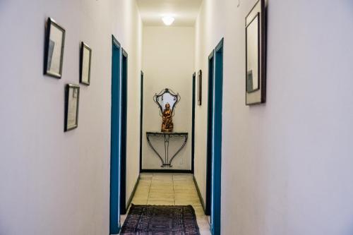 a hallway with blue doors and a clock on the wall at Pousada Encanto de Tiradentes in Tiradentes