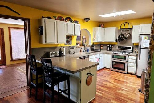 a kitchen with white cabinets and a kitchen island with chairs at Casa Karina in Santa Fe