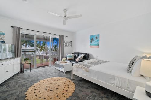 Un dormitorio blanco con una cama y un sofá. en The Resort at Dolphin Heads, en Mackay