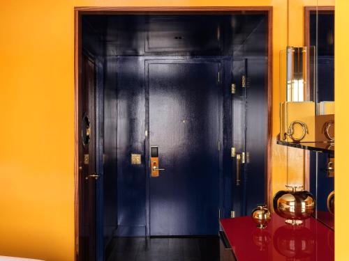 a black door in a room with a yellow wall at The Manner, The Unbound Collection by Hyatt in New York