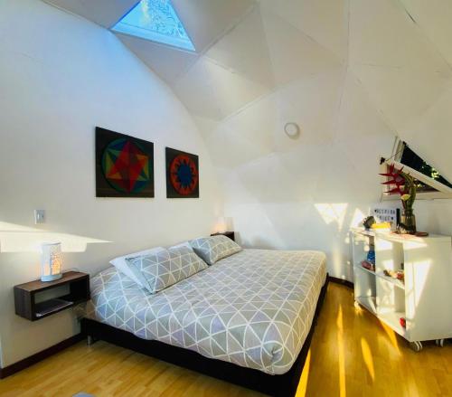 a bedroom with a bed in a white room at Eco Lodge Glamping in Guatapé