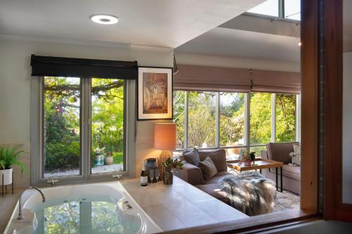 a living room with a large tub in a room at The Acorn -open fire,spa bath,dog friendly in Daylesford