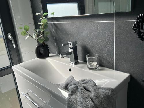 a bathroom with a white sink and a mirror at Enkhuizer Strand Chalet WolkeSieben Dritte Reihe mit Zaun Hausnr 202 in Enkhuizen