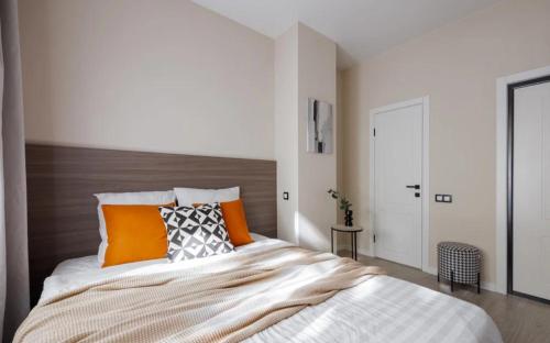 une chambre avec un lit avec des oreillers orange et blancs dans l'établissement 1 Bd Green Home OAK, à Lille