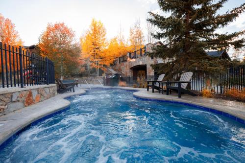 a swimming pool with two benches in a yard at Ski in Ski out Resort Breckenridge 1BR 2Beds Parking, Resort Shuttle & Amenities in Breckenridge