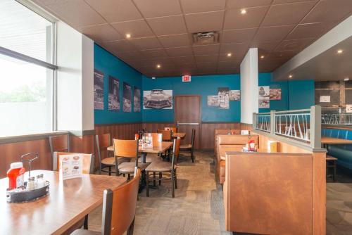 a restaurant with wooden tables and chairs and blue walls at Sandman Hotel Lethbridge in Lethbridge