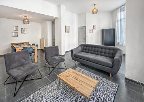 un salon avec un canapé et deux chaises dans l'établissement Spacieuse maison, 4 chambres, Wi-Fi et Parking, à Tourcoing