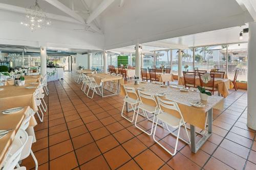 a dining room with tables and chairs and windows at The Resort at Dolphin Heads in Mackay