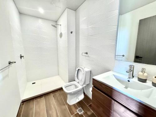 ein weißes Badezimmer mit Toilette und Waschbecken in der Unterkunft Apartamento Lujoso y Comodo con la mejor vista panoramica de Santa Cruz in Hamacas