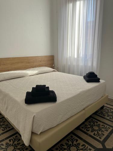 a bed with two towels sitting on top of it at Civico 9 in Bonorva