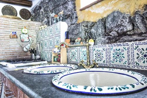a bathroom with two sinks and a stone wall at La Tavernetta in Santa Venerina