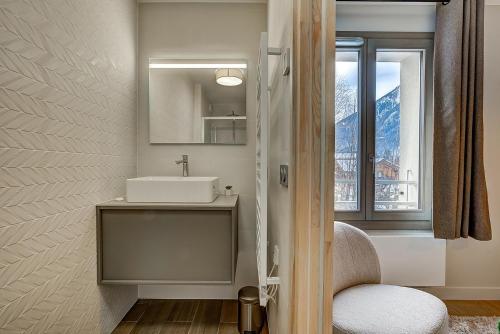 une salle de bain avec un lavabo, un miroir et une fenêtre dans l'établissement White Pearl - Centre de Chamonix - 2ch - Renove, à Chamonix-Mont-Blanc