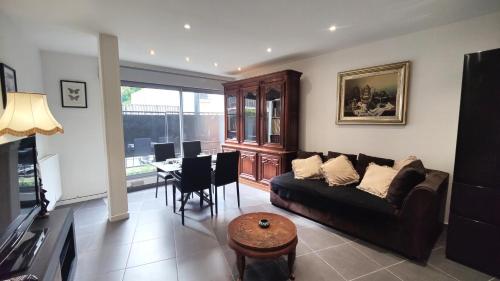 un salon avec un canapé et une table dans l'établissement L'Écrin Parisien - Proche Métro -Direct Paris - 4 personnes, à Romainville