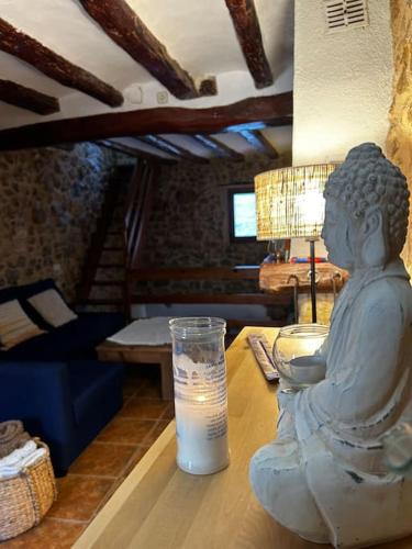 a statue of a girl sitting on a table with a drink at Rural Stone House with wood fireplace in Pinell de Bray