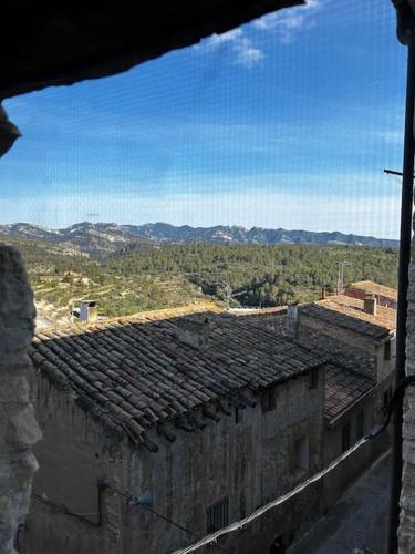 a view of an old building with mountains in the background at Rural Stone House with wood fireplace in Pinell de Bray