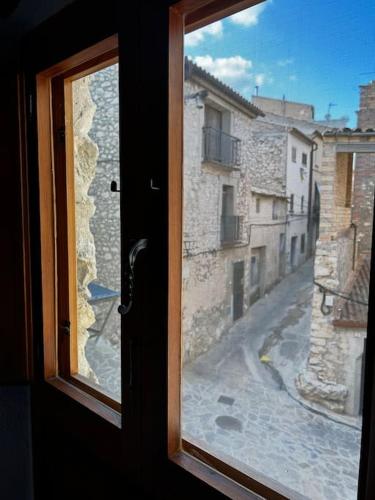 an open window with a view of a street at Rural Stone House with wood fireplace in Pinell de Bray