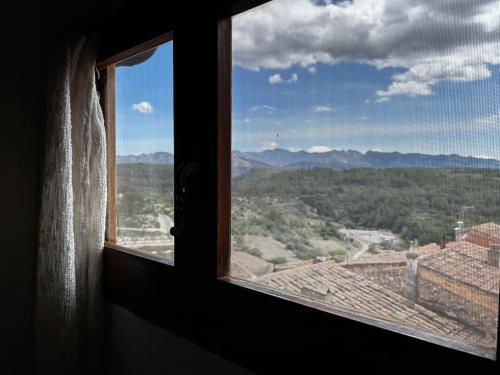 a window with a view of a mountain view at Rural Stone House with wood fireplace in Pinell de Bray
