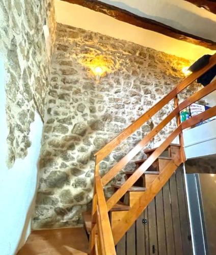 a staircase in a room with a stone wall at Rural Stone House with wood fireplace in Pinell de Bray