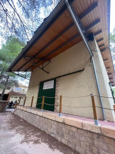 a building with a green door on the side of it at Rural Stone House with wood fireplace in Pinell de Bray