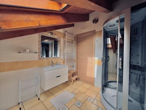 アジェーロラにあるHome Sweet Home Apartmentのシャワー、洗面台、鏡を備えたバスルーム