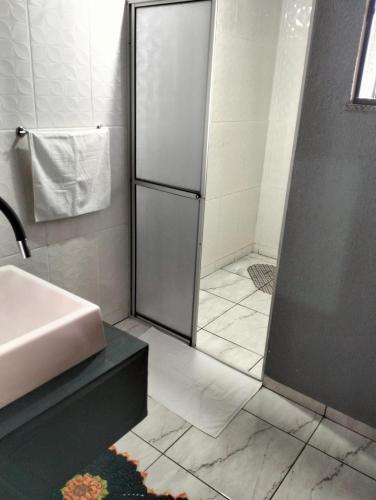 a bathroom with a shower with a sink and a showeriterator at Sobrado para hóspedes in Guarapuava