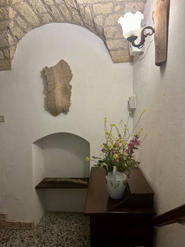 a room with a vase of flowers on a table at Casa del Gelsomino in Cuglieri