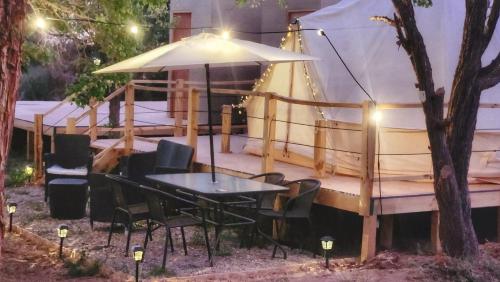 a table and chairs in front of a boat at Glamping Dunas del sol in San Pedro de Atacama