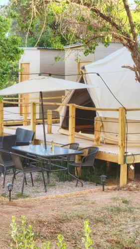 a patio with a table and chairs and a tent at Glamping Dunas del sol in San Pedro de Atacama