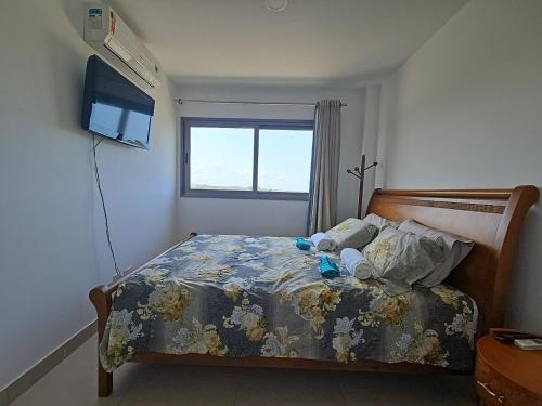 a bedroom with a bed and a television in it at Condomínio de Luxo Praia do Forte - Iberostate - refugio de paz in Praia do Forte