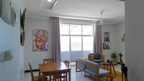 乌罗阿Spacious Beachfront Condo -AC - WIFI, Uroa Escape Zanzibar的带桌子的客厅和餐厅