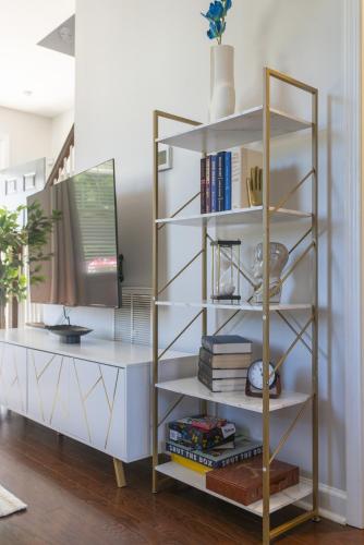 a white book shelf with books on it at Fam-Biz Friendly 3BD with Fire pit & BBQ - Downtown in Raleigh