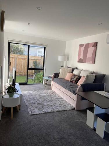 a living room with a couch and a table at Modern, trendy apartment in Lower Hutt