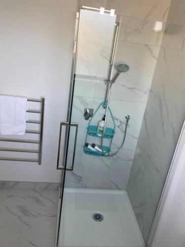 a shower with a glass door in a bathroom at Modern, trendy apartment in Lower Hutt