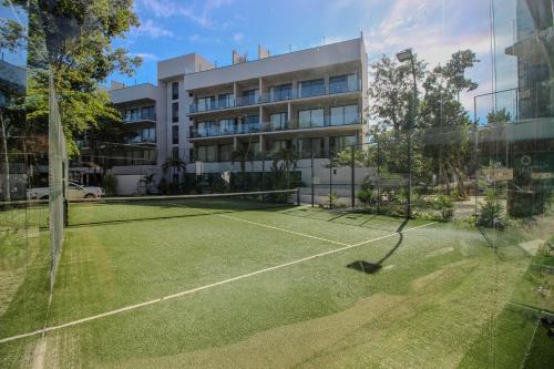a tennis court in front of a building at Top Location Studio with Rooftop Pool, Gym and Padel Court in Tulum