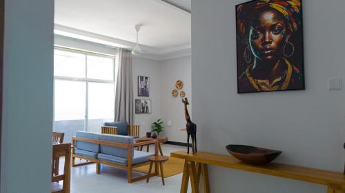 a living room with a portrait of a woman on the wall at Spacious Beachfront Condo -AC - WIFI, Uroa Escape Zanzibar in Uroa