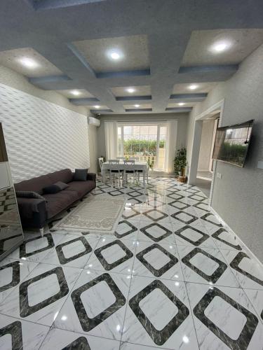 a living room with a large white tile floor at Sweet Villa in Dǝnizkǝnarı Stansiyası