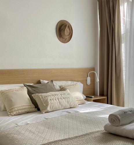 a bed with white sheets and pillows in a bedroom at Terral Suites in Mar de las Pampas