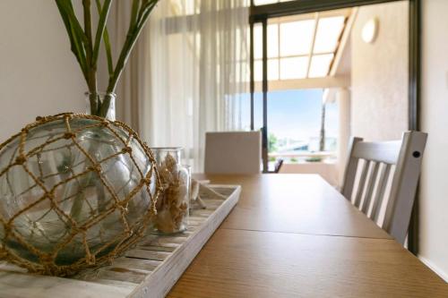 a dining room table with a basket on top of it at The Noosa Apartments in Noosa Heads