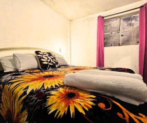 a bedroom with a bed with sunflowers on it at Río Rooms City Center in Quetzaltenango