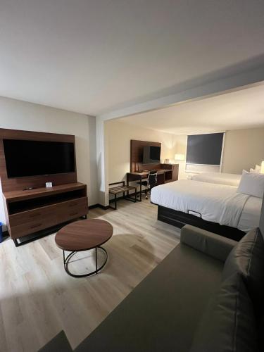 a large hotel room with a bed and a couch at Wingate by Wyndham I-81 Exit 101- Newly Renovated in Dublin