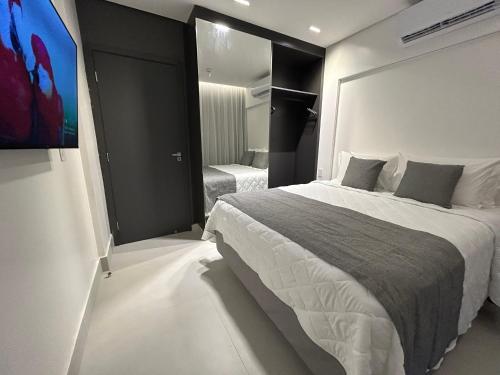 a bedroom with a large bed and a television at Porto Alto Resort GAV em Muro Alto in Cupe
